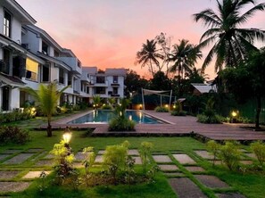 A modern hotel with a swimming pool, well-maintained gardens, and palm trees. - Cozy 1BR Apt in Siolim 3km to Uddo Beach (Siolim)