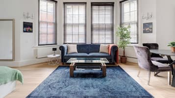 Relax in this stylish living room with a sofa, dining area, and potted plant.