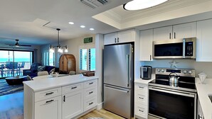 Una cocina moderna con armarios blancos, electrodomésticos de acero inoxidable y una isla grande.