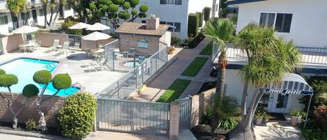 Um imóvel residencial com piscina, varanda coberta e jardim bem cuidado.