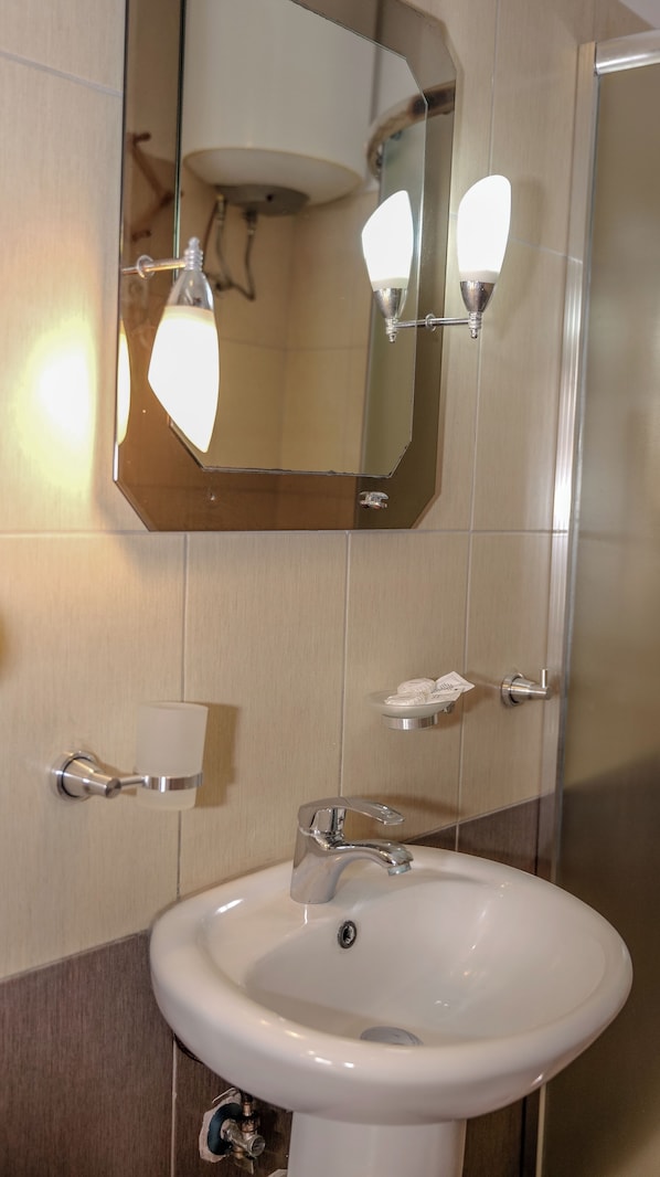 A bathroom with a white sink, a mirror, and a towel rack.