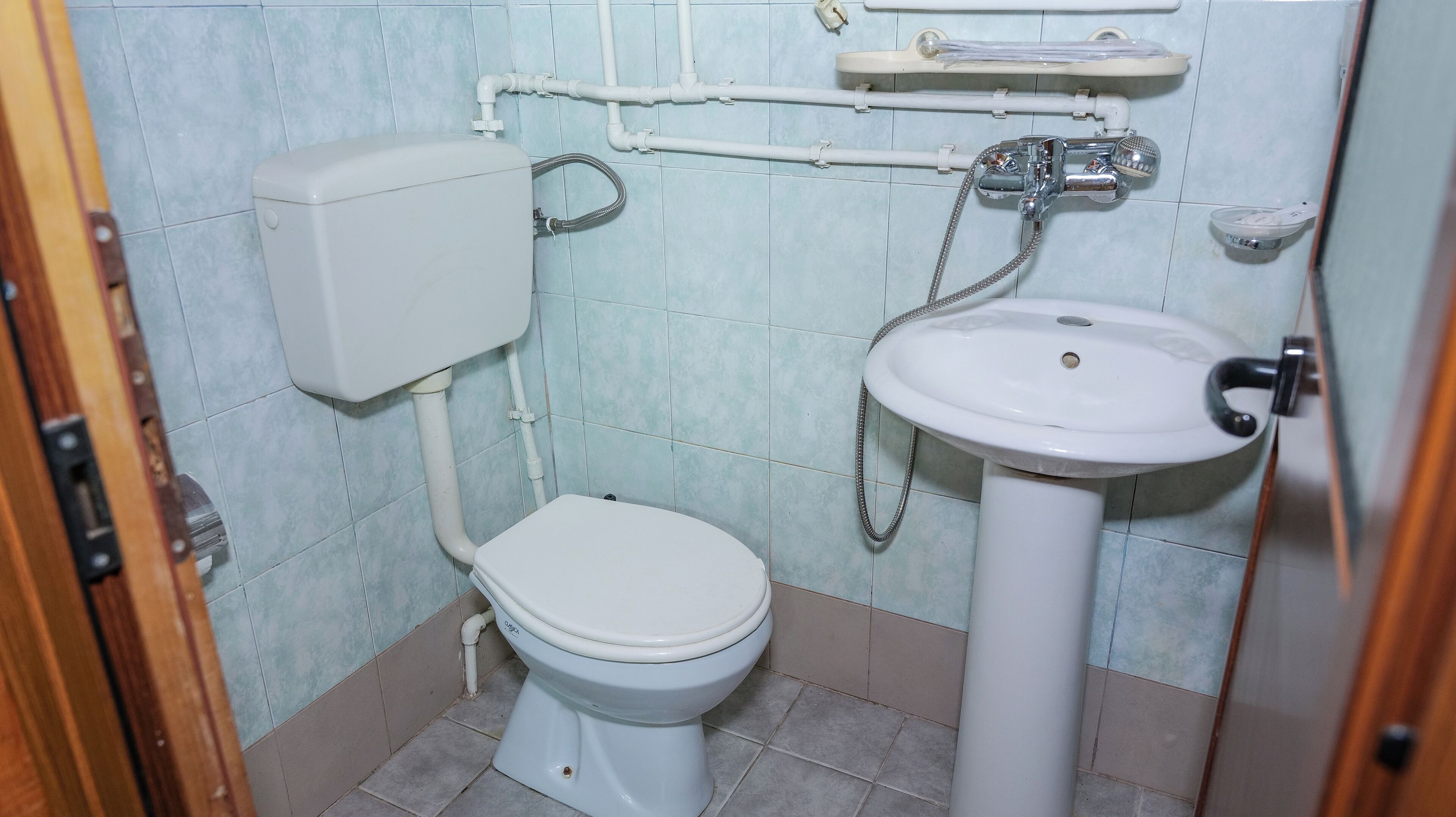 A small bathroom with a toilet, a sink, and a shower.