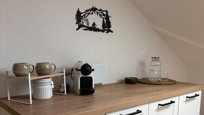 A kitchen with white cabinets, a wooden countertop, and a black decorative wall piece. - ALLGÄUHERZ - Great apartment in Nesselwang - KÖNIGSKARTE (Nesselwang)