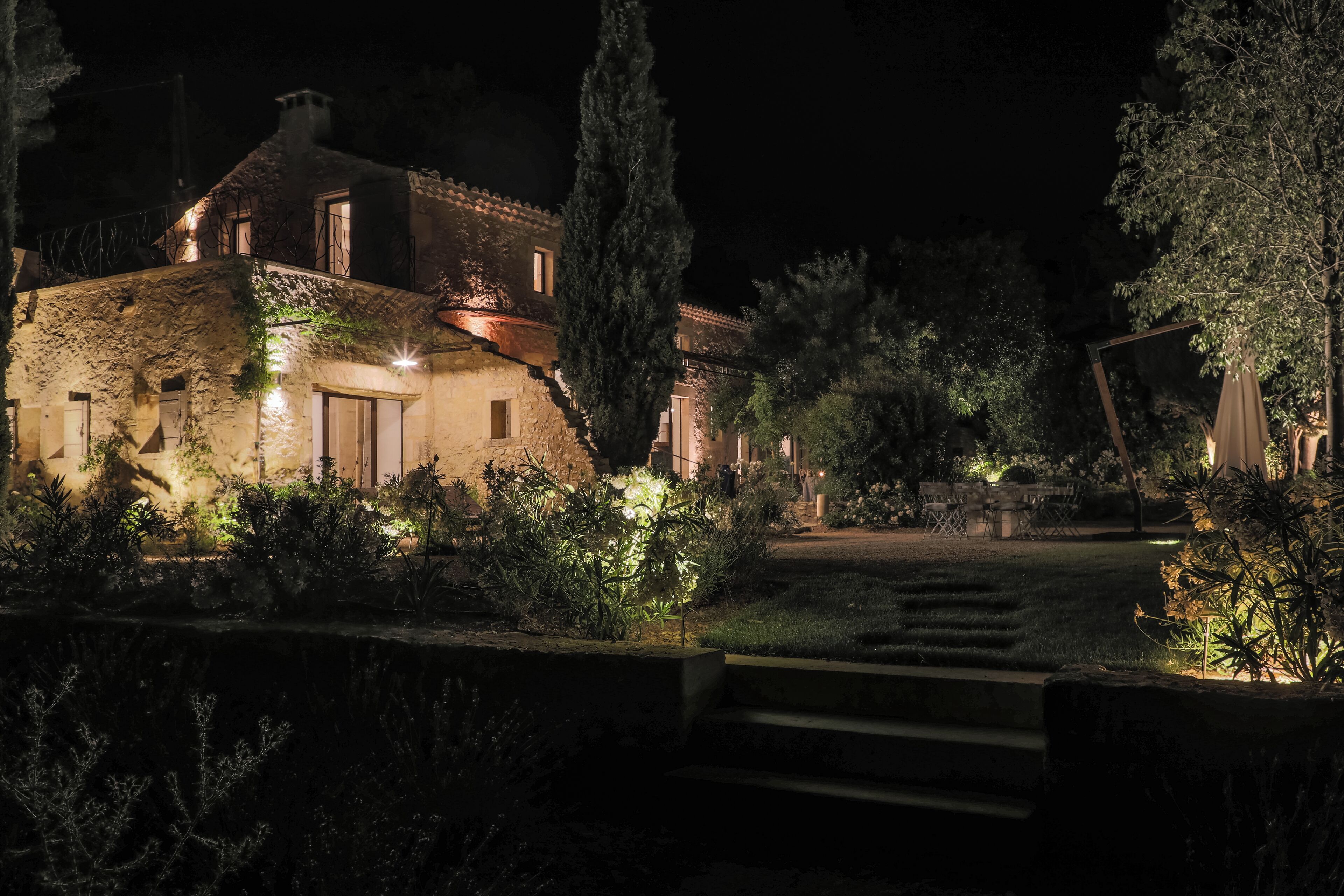 Une maison en pierre dotée d’une entrée bien éclairée et d’un jardin.