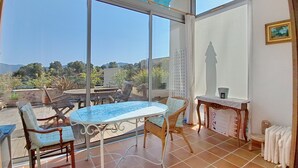Un balcón con mesa y sillas, vista del paisaje y un radiador.