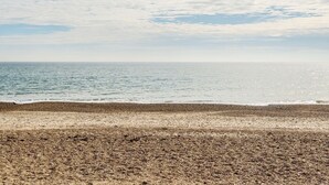 A beach with a pebbly shore and a calm sea under a partly cloudy sky. - Mariner's Meadow - Hayling Island (Hayling Island)