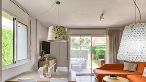 Een moderne woonkamer met een bank, een eettafel en een televisie.