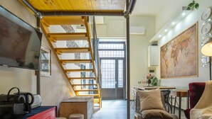 Una cocina moderna con una escalera de madera, un comedor con una silla roja y un gran mapa del mundo en la pared.