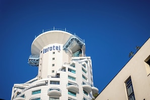 A hotel with a distinctive cylindrical tower and balconies.