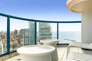 A balcony with a city view, two white round tables, and a white lounge chair. - Magnificent Seaside Panorama Stay by Sea N' Rent (Tel Aviv-Yafo)