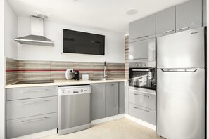 A modern kitchen with stainless steel appliances, a dishwasher, and a built-in oven. - Magnificent Seaside Panorama Stay by Sea N' Rent (Tel Aviv-Yafo)