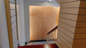 Una escalera con paneles de madera y barandilla roja.