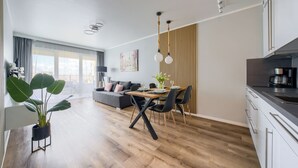A modern apartment with a dining area, kitchen, and living space.