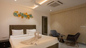 A modern hotel room with a large bed, a ceiling fan, and a decorative wall piece. - Let Home (Hyderabad)
