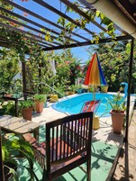 Una piscina al aire libre, sombrillas, sillones reclinables de piscina