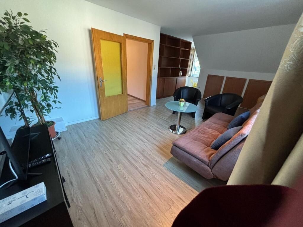 A modern living room with a sofa, a round table, and a potted plant.