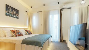Une chambre d’hôtel avec un lit, des rideaux, une télévision et un tableau au mur.