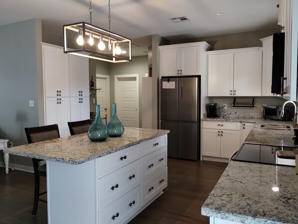 Enjoy cooking in this well-equipped kitchen with a central island, sink, and oven.