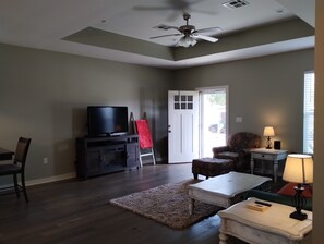 Relax in this inviting living room with a flat-screen TV, plush rug, and comfortable seating areas.