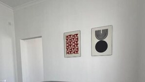 A living room with a gray sofa, a round coffee table, and two framed artworks on the wall. - UNO Hotel Jalal-Abad (Jalal-Abad)