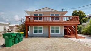A two-story house with a balcony, a garage, and a driveway.