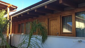 Un edificio con paredes exteriores de madera, ventanas grandes y una puerta visible.