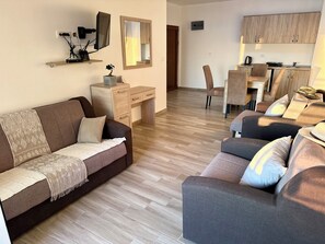 A modern living room with a sofa, a desk, and a dining area. - Saray Hotel (Bar)