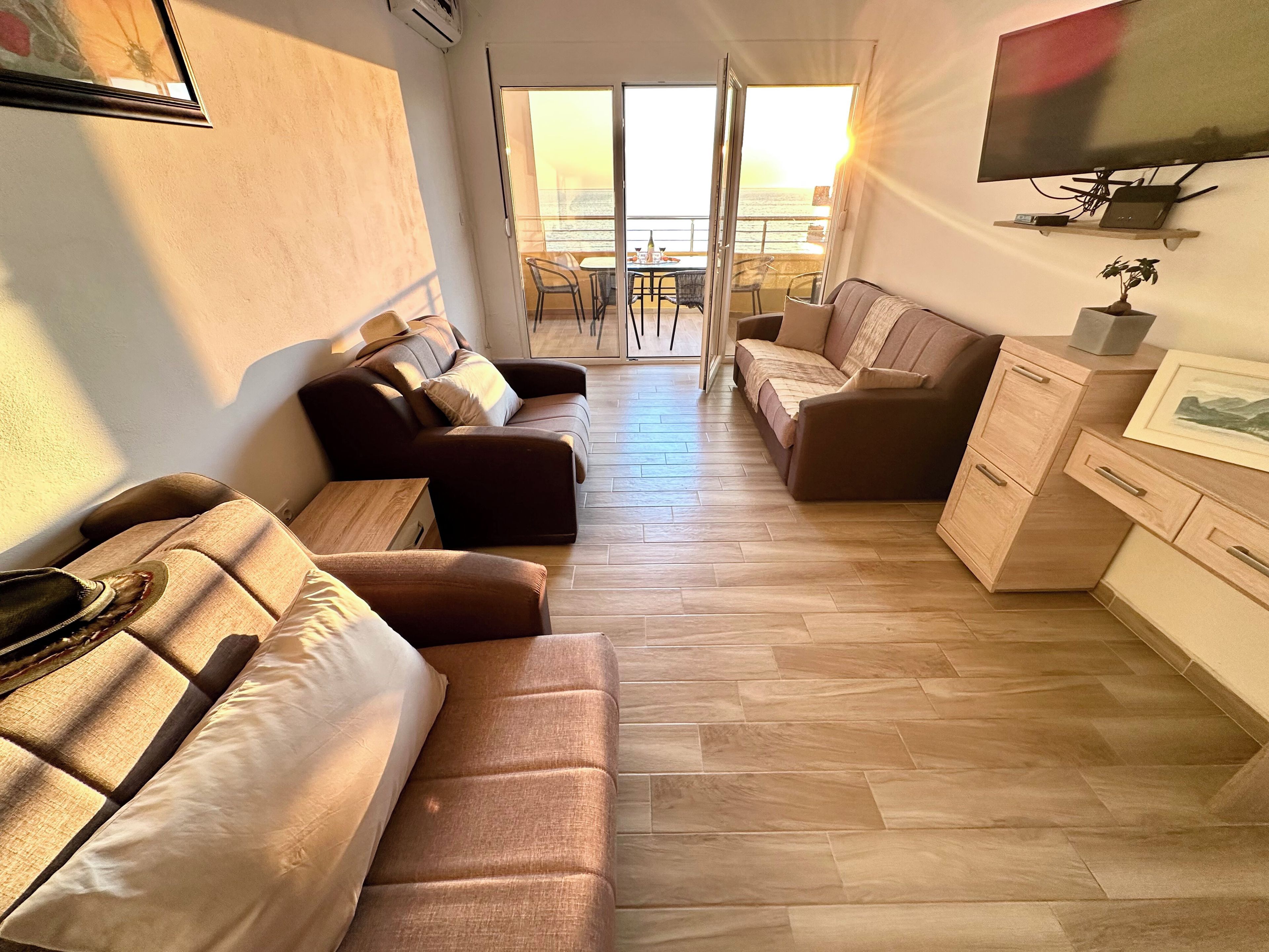 Una sala de estar moderna con sofá, mesa de centro, televisión y balcón con vistas.