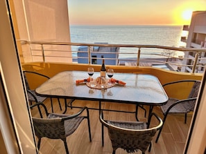 A balcony with a table set for two, a bottle of red wine, and a glass of wine. - Saray Hotel (Bar)