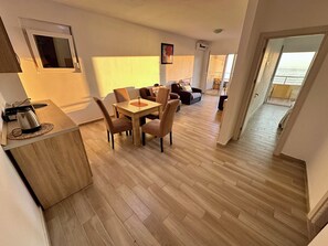 A modern apartment with a dining area, kitchen, and a balcony with a view. - Saray Hotel (Bar)