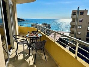 A balcony with a table set for two, overlooking a coastal view. - Saray Hotel (Bar)