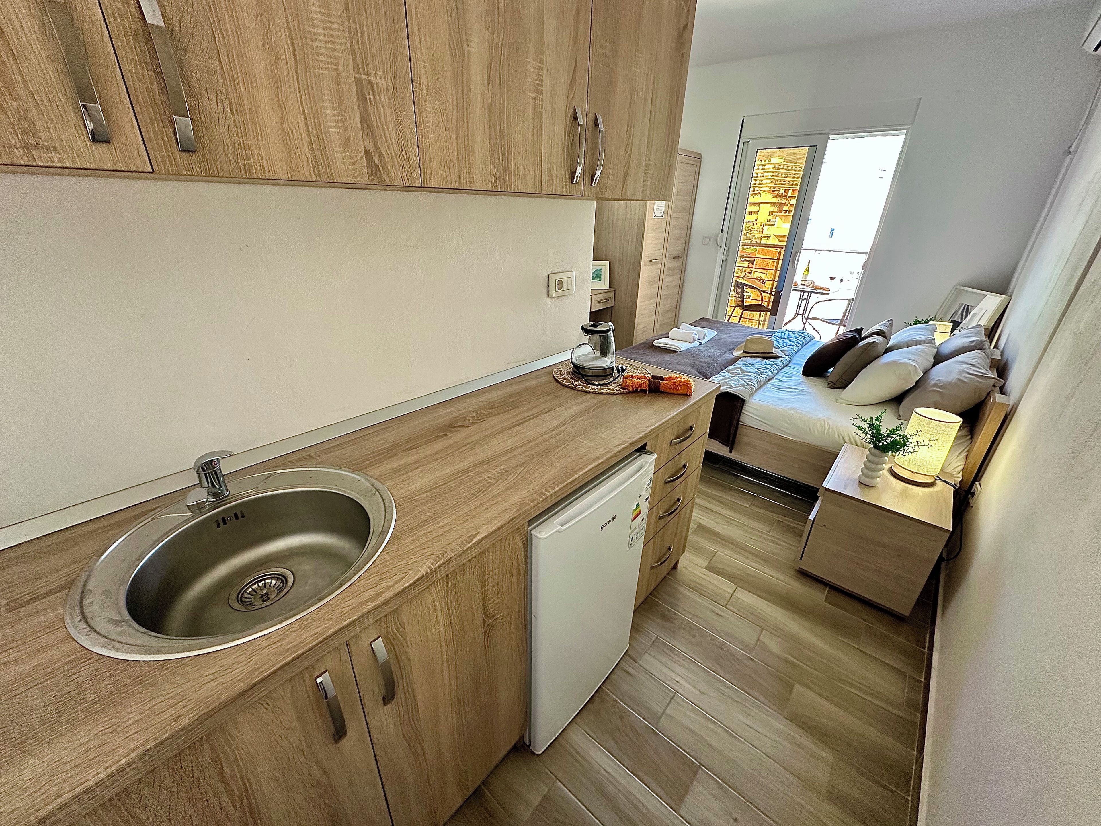 A compact kitchen with a sink, dishwasher, and wooden cabinets.