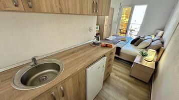 A compact kitchen with a sink, dishwasher, and wooden cabinets.