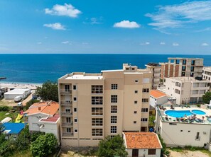 A multi-story hotel with a rooftop pool and a view of the sea. - Saray Hotel (Bar)