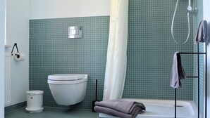A bathroom with a toilet, a shower, and a bathtub. - Double room in the Gasthaus am Finowkanal (former school from 1875). (Wandlitz)