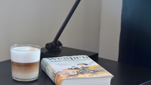 A book titled "The Voyaging Spoon" and a glass of coffee on a table. - Double room in the Gasthaus am Finowkanal (former school from 1875). (Wandlitz)