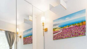 Un salon moderne avec un canapé, une table ronde et un grand miroir.