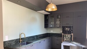 A modern kitchen with grey cabinets, a granite countertop, a gold faucet, and a pendant light. - Your cosy, quiet suite in the heart of Carcassonne! (Carcassonne)