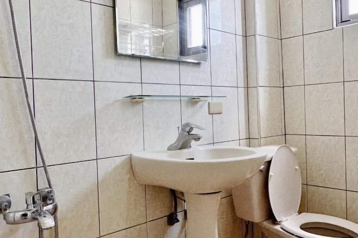 Un baño con lavamanos, inodoro y espejo.
