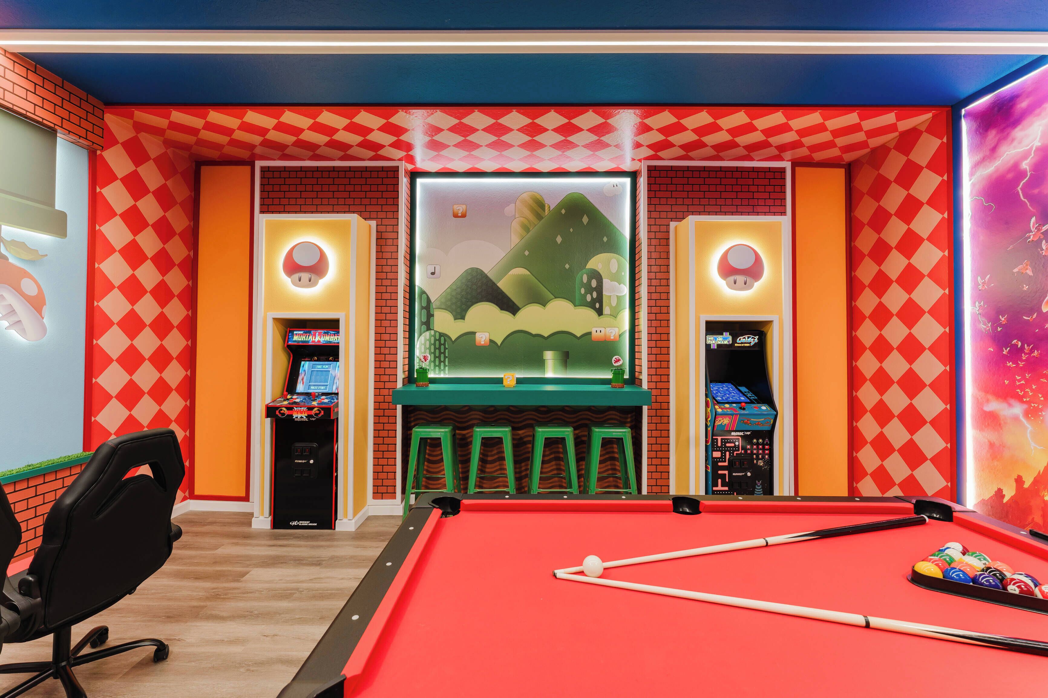 A pool table with green stools, a pool cue, and a Nintendo 64 gaming console.