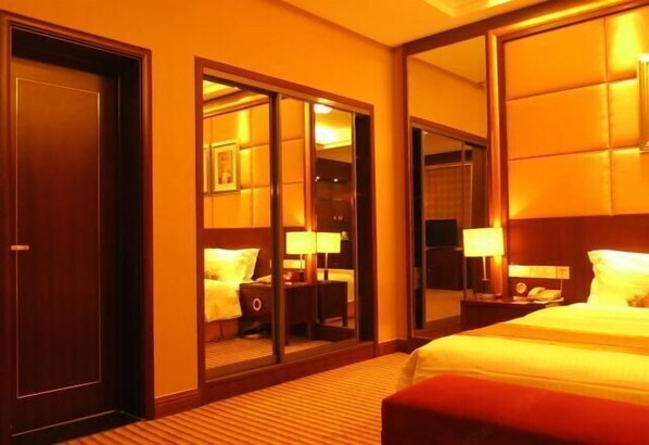 Relax in a cozy space with a large bed, nightstand, and mirror.