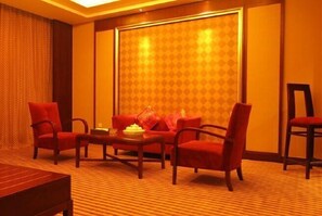 Relax in a cozy space with a large window, patterned curtain, and plush carpeting.