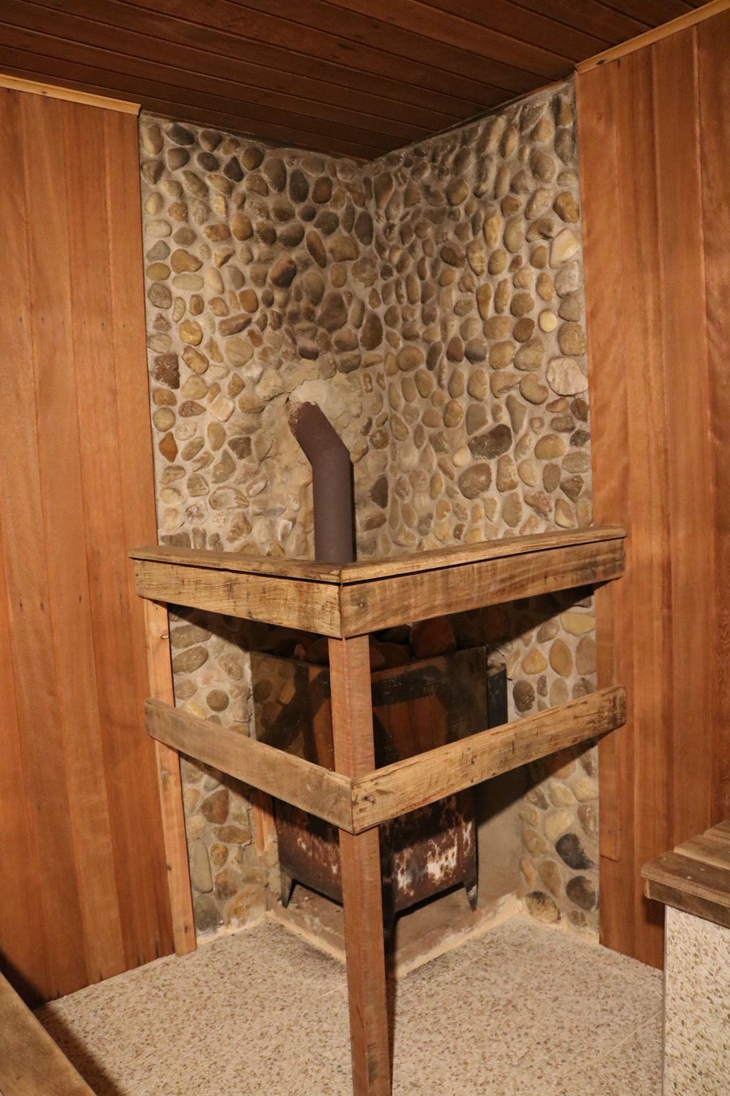 Eine rustikale Steinmauer mit einem Holztisch davor.