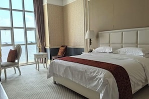 Relax in this inviting room with a large bed, sea views, and a cozy reading nook.