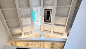 Ein Zimmerblick mit schräg steilendem Dach und einem Oberlicht.