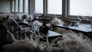 A dining area with tables set for a meal, large windows, and a view of the outdoors. - Eqi Glacier Lodge - World of Greenland (Ilulissat)