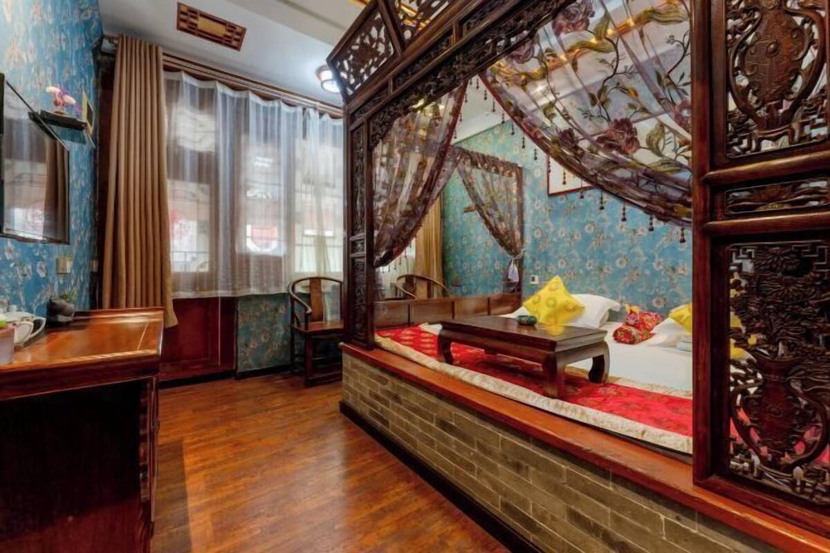 Une chambre traditionnelle avec un lit en bois, un bureau et une chaise.