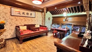 Ein traditionell eingerichteter Raum mit einer Holzsofa, einem Esstisch und einer Wanddekoration.