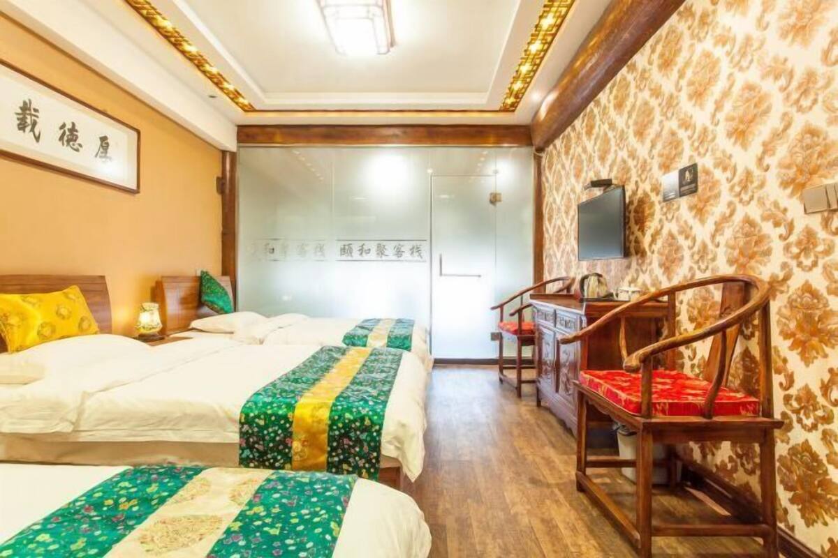 Une chambre d’hôtel avec deux lits, un bureau et une chaise.