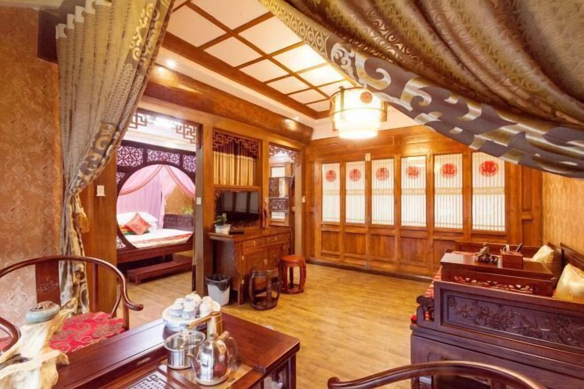 Une chambre de style traditionnel, avec un lit, des meubles en bois et une fenêtre décorative.